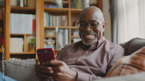 Happy guy on sofa with smartphone