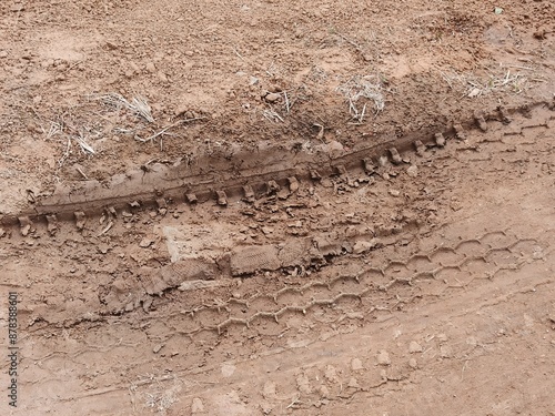 Tire tracks on light red soil.