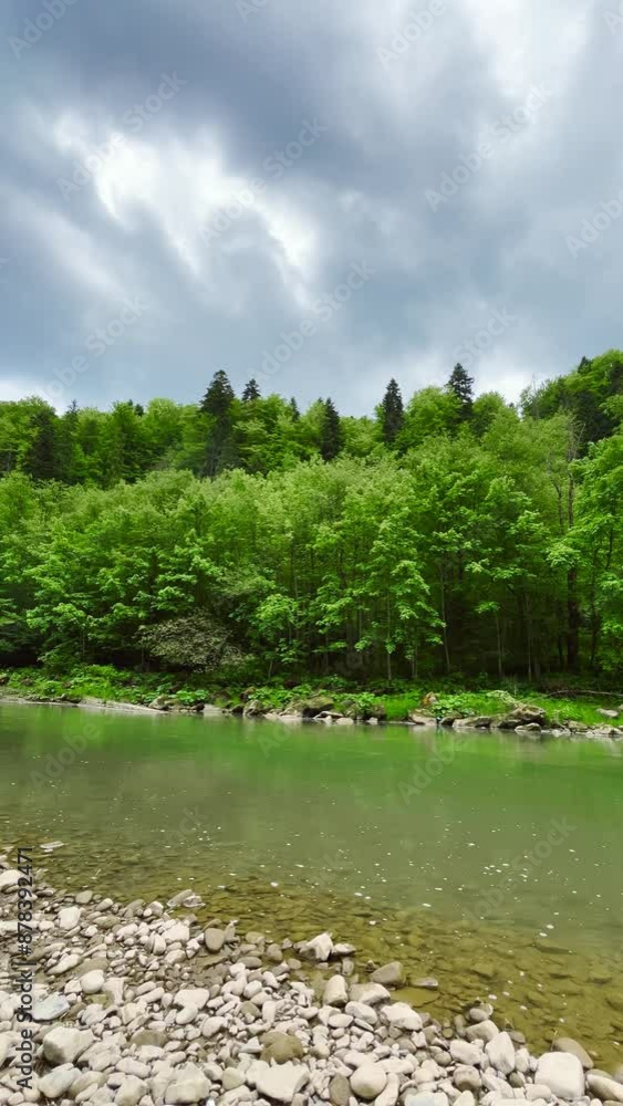 Water flow in a mountain river. Thunderstorm and rain clouds in the sky. Vertical video. Water flow in a mountain river. Thunderstorm and rain clouds in the sky. Vertical video.