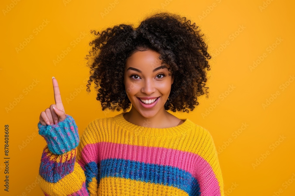 An image of a speechless woman with curly hair wearing a striped top with an empty space on her arm, isolated on a yellow background An image of a speechless woman with curly hair wearing a striped top with an empty space on her arm, isolated on a yellow background