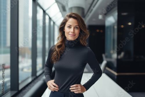 Portrait of a glad woman in her 30s showing off a thermal merino wool top in sophisticated corporate office background Free Download Portrait of a glad woman in her 30s showing off a thermal merino wool top in sophisticated corporate office background - GFXLoad