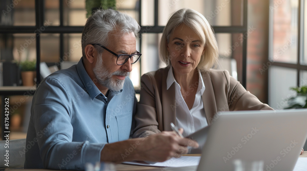 Elderly pair viewing computer indoors Elderly pair viewing computer indoors