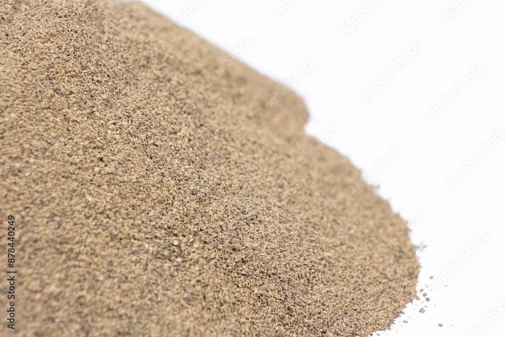 Spilled ground black pepper spicy seasoning on a white background Spilled ground black pepper spicy seasoning on a white background