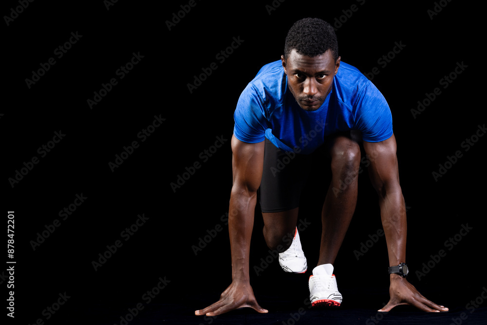 African American man in starting position for a sprint, with copy space on a black background African American man in starting position for a sprint, with copy space on a black background