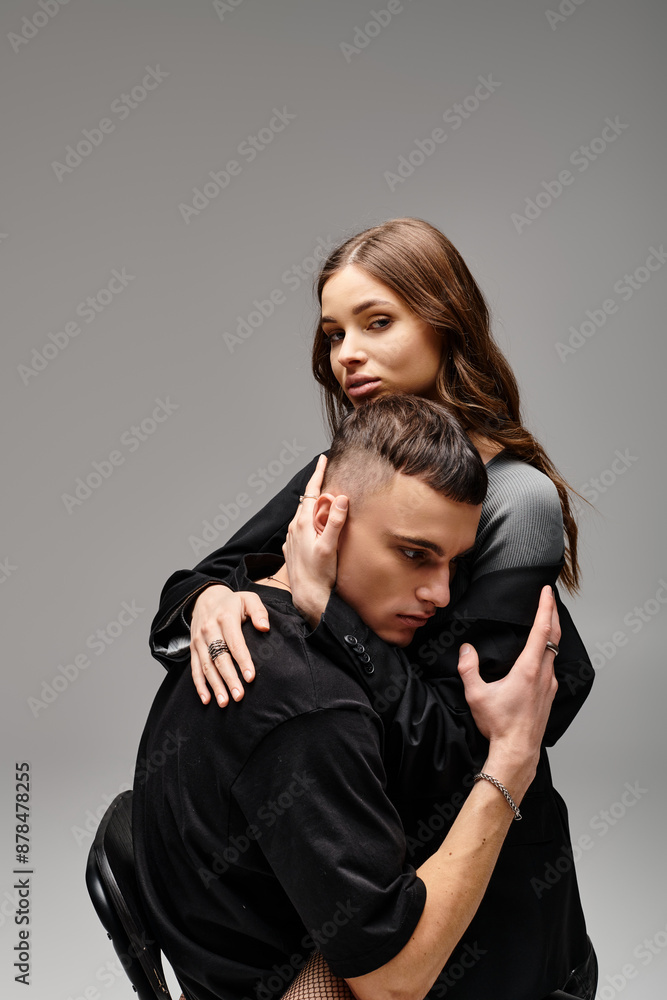 A man tenderly embraces a woman in a chair, their bodies intertwined, conveying a sense of love and intimacy. A man tenderly embraces a woman in a chair, their bodies intertwined, conveying a sense of love and intimacy.