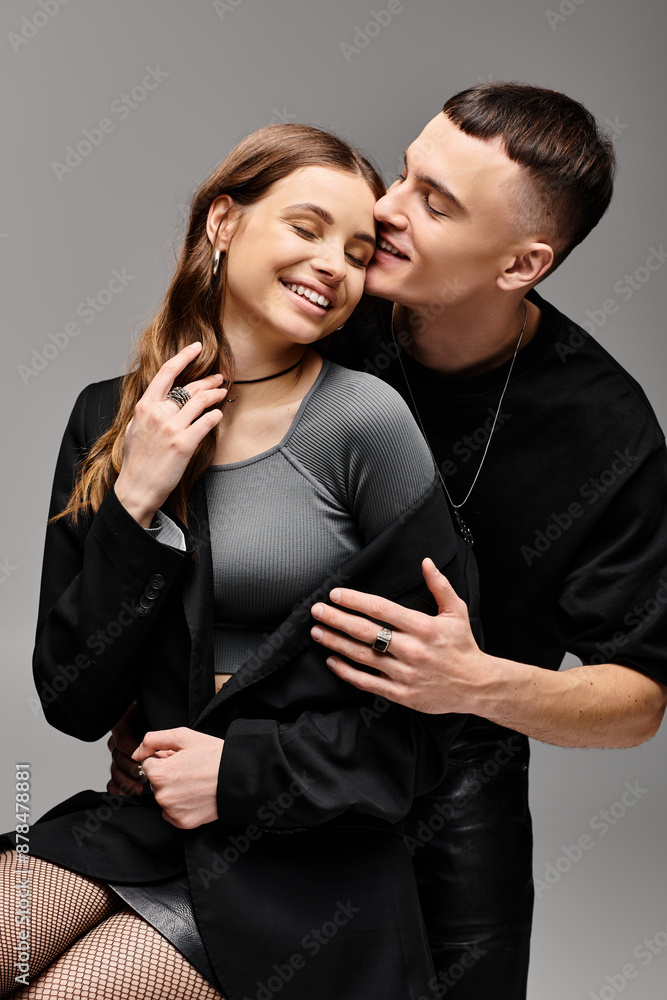 A young couple in love poses in a studio with a grey background, exuding grace and harmony. A young couple in love poses in a studio with a grey background, exuding grace and harmony.