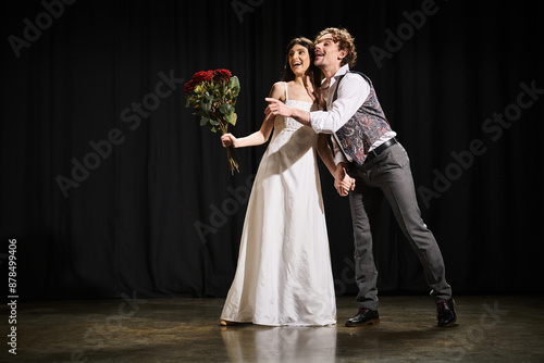 Photography A man and a woman stand confidently on a theater stage during rehearsals