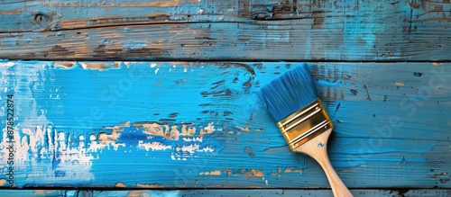 Using a paintbrush, create a blue design on a wooden board with copy space image.