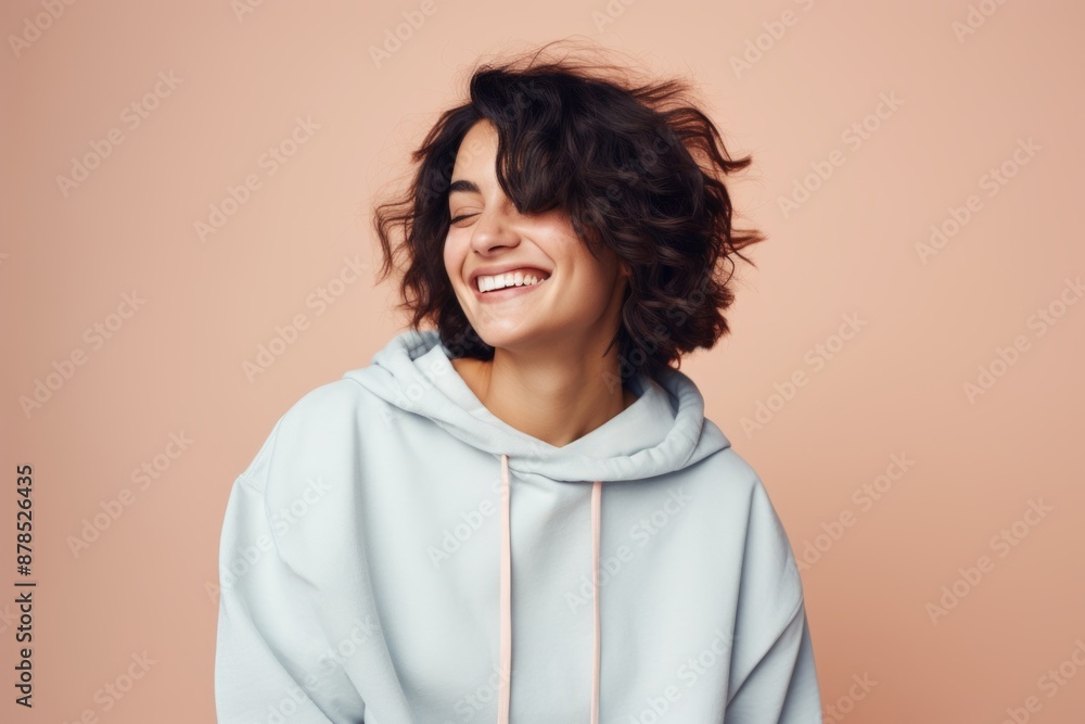Portrait of a satisfied woman in her 30s sporting a comfortable hoodie over pastel or soft colors background Portrait of a satisfied woman in her 30s sporting a comfortable hoodie over pastel or soft colors background