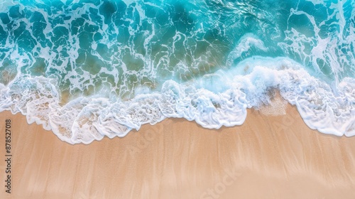 Turquoise ocean water is creating white foam on a sandy beach, providing a beautiful background for a summer vacation concept © Viktoriia