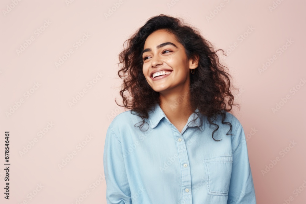 Portrait of a joyful indian woman in her 20s sporting a versatile denim shirt isolated on pastel or soft colors background Portrait of a joyful indian woman in her 20s sporting a versatile denim shirt isolated on pastel or soft colors background