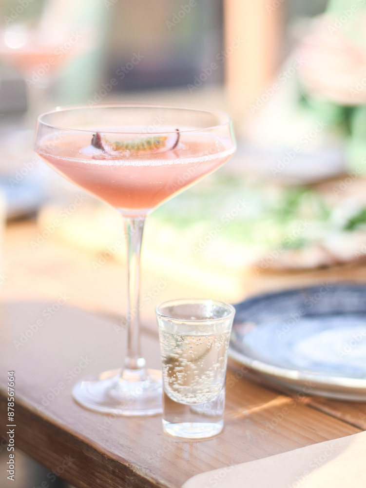 Alcoholic drink with passion fruit in a beautiful glass with a glass of vodka on a wooden table Alcoholic drink with passion fruit in a beautiful glass with a glass of vodka on a wooden table