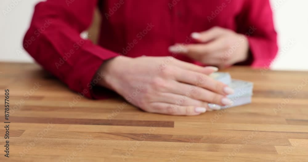 Woman worker picks up bundles of money from office table Woman worker picks up bundles of money from office table
