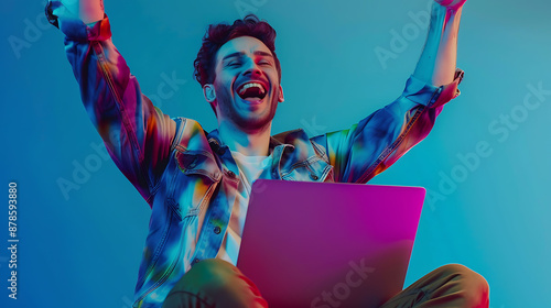 Man in vibrant shirt, laptop, joyful, celebrating success.
