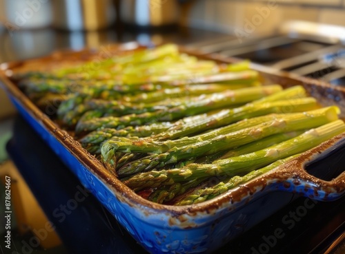 Baked asparagus with cheese in a white baking dish on an oven rack.