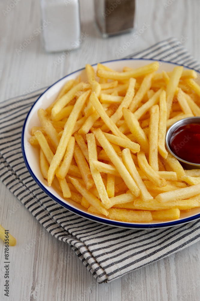 Homemade American French Fries with Ketchup on a Plate, side view. Homemade American French Fries with Ketchup on a Plate, side view.
