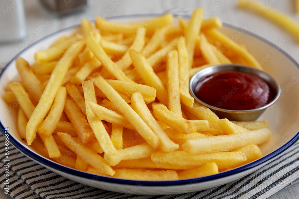 Homemade American French Fries with Ketchup on a Plate, side view. Close-up. Homemade American French Fries with Ketchup on a Plate, side view. Close-up.