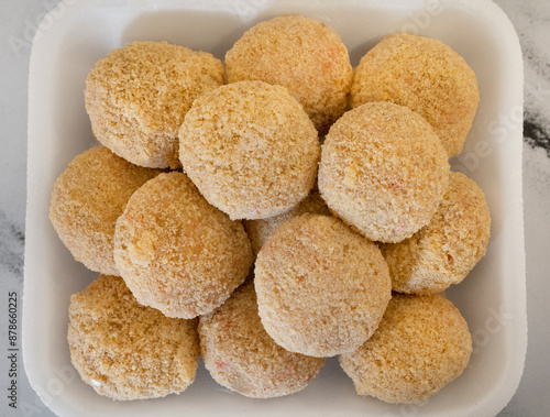 Top view of uncooked breaded fish croquettes ready for cooking