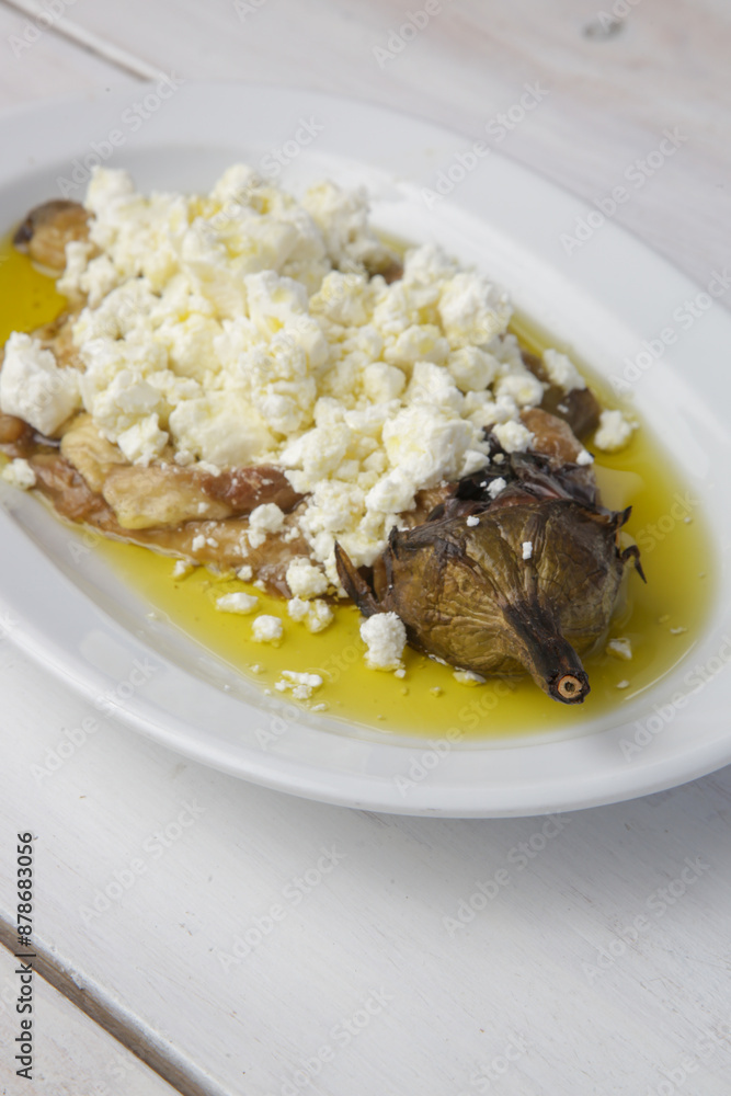 Mediterranean cuisine, roasted eggplant stuffed with feta cheese in olive oil Mediterranean cuisine, roasted eggplant stuffed with feta cheese in olive oil