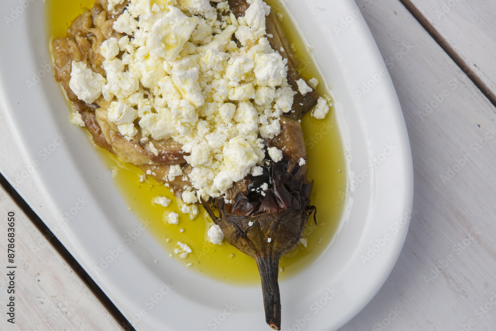 Mediterranean cuisine, roasted eggplant stuffed with feta cheese in olive oil Mediterranean cuisine, roasted eggplant stuffed with feta cheese in olive oil