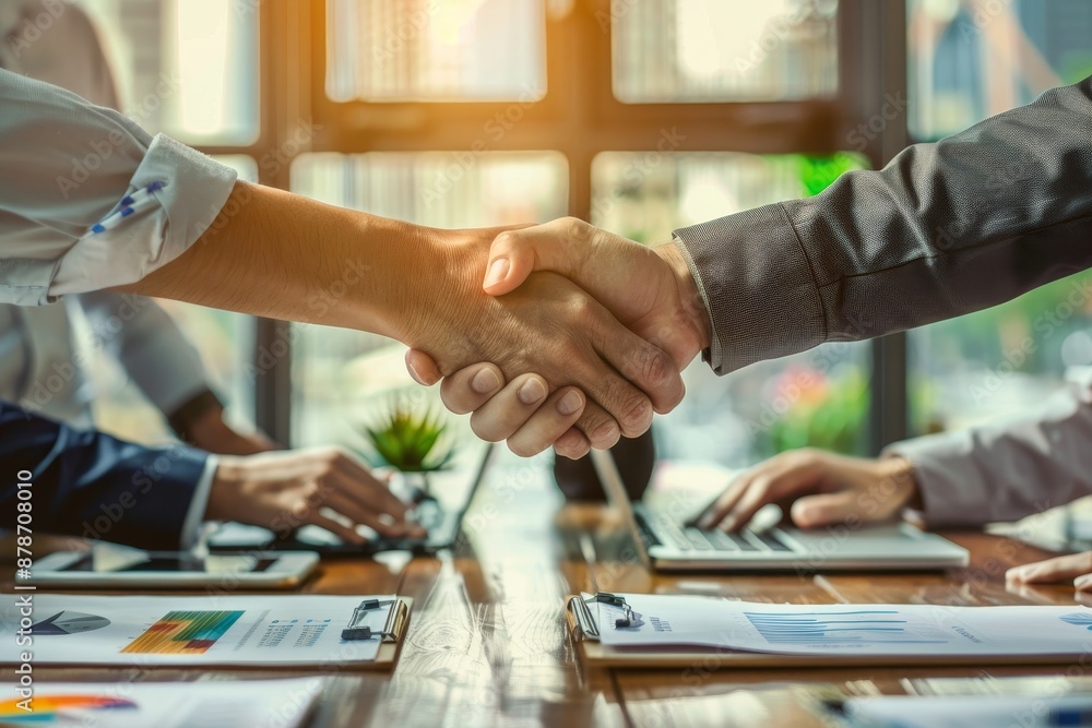 A group of people collaborating and shaking hands around a table during a business meeting, Collaborating with other investors to share insights and expertise A group of people collaborating and shaking hands around a table during a business meeting, Collaborating with other investors to share insights and expertise