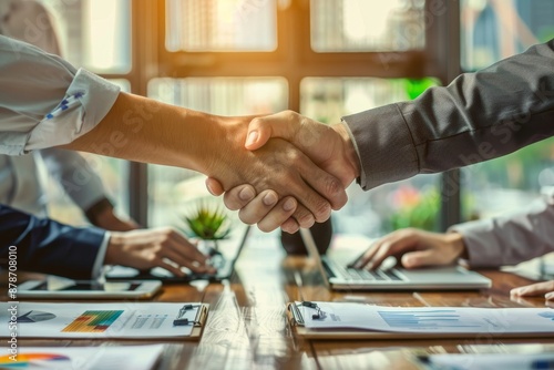 Wallpaper Mural A group of people collaborating and shaking hands around a table during a business meeting, Collaborating with other investors to share insights and expertise Torontodigital.ca