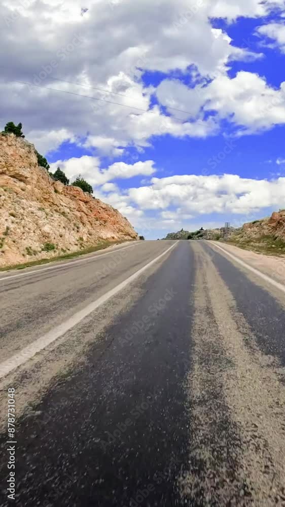 A mesmerizing drive along a winding road in the Turkish mountains, with a breathtaking rock outcropping in the distance A mesmerizing drive along a winding road in the Turkish mountains, with a breathtaking rock outcropping in the distance