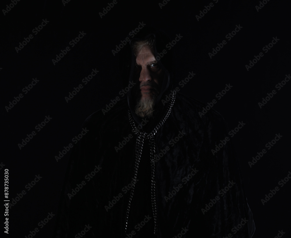 monk in a black hood on a black background