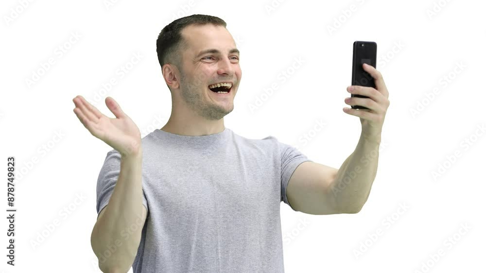 A man in a gray T-shirt, on a white background, close-up, with a phone A man in a gray T-shirt, on a white background, close-up, with a phone