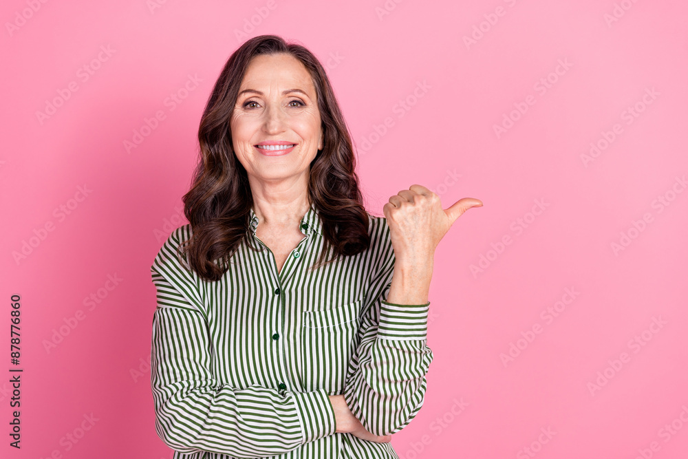 Photo of charming positive woman wear striped shirt showing thumb empty space isolated pink color background Photo of charming positive woman wear striped shirt showing thumb empty space isolated pink color background