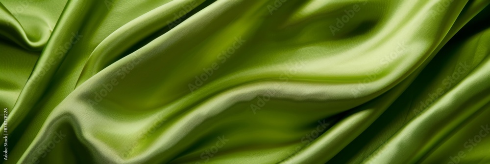 Green drapery silk fabric background. Wavy satin cloth texture pattern. Smooth shiny drape material Green drapery silk fabric background. Wavy satin cloth texture pattern. Smooth shiny drape material