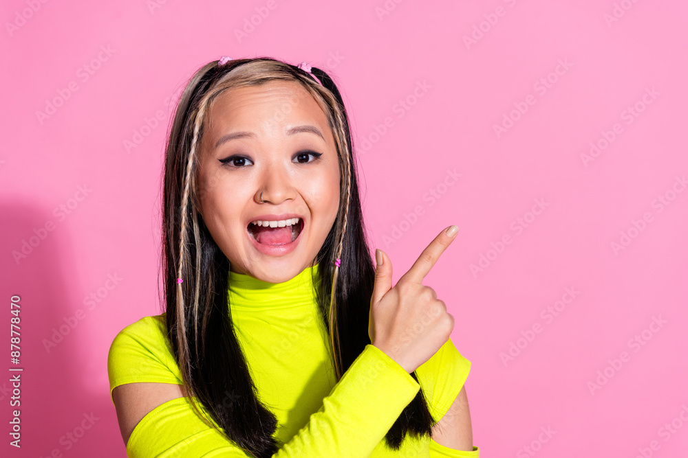 Photo of impressed girl with dyed hairstyle dressed yellow turtleneck directing at promo empty space isolated on pink color background Photo of impressed girl with dyed hairstyle dressed yellow turtleneck directing at promo empty space isolated on pink color background