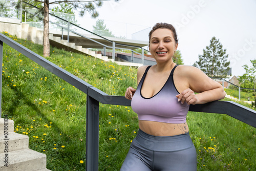 Tired plus size sportswoman resting on stairs