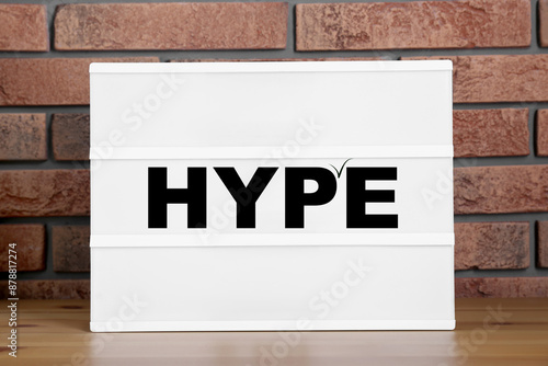 Tableau sur toile Hype word on sheet of paper against brick wall