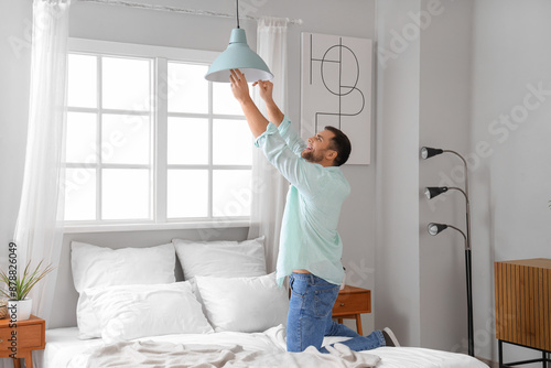 Young man changing light bu...