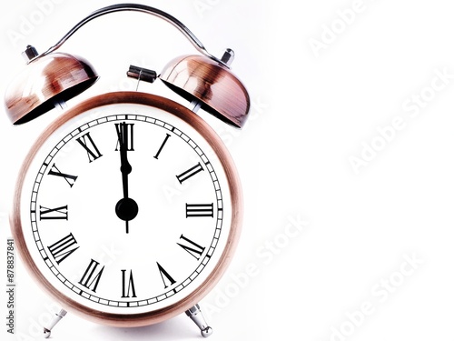 Minimalist vintage alarm clock isolated on a white background at 12am 12pm. Simple retro roman numeral clock at 12 o'clock and space for text photo