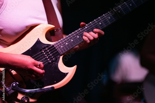 female musician playing guitar band at a rock show to an audience watching. sound check with a switcher in a music venue photo