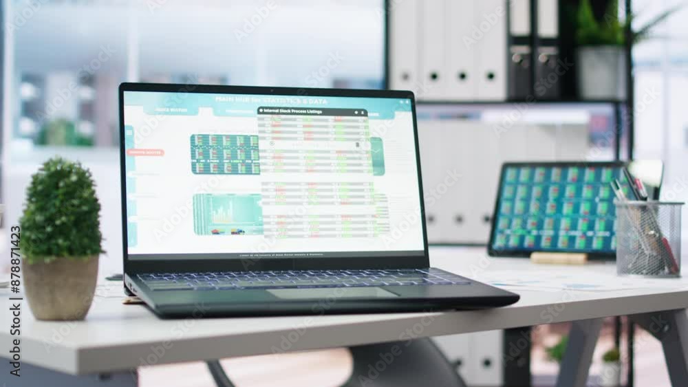 Empty office with stock portfolio on devices containing collection of investment bonds and other financial assets. Real time index indices showing stock demand surge on laptop and tablet Empty office with stock portfolio on devices containing collection of investment bonds and other financial assets. Real time index indices showing stock demand surge on laptop and tablet