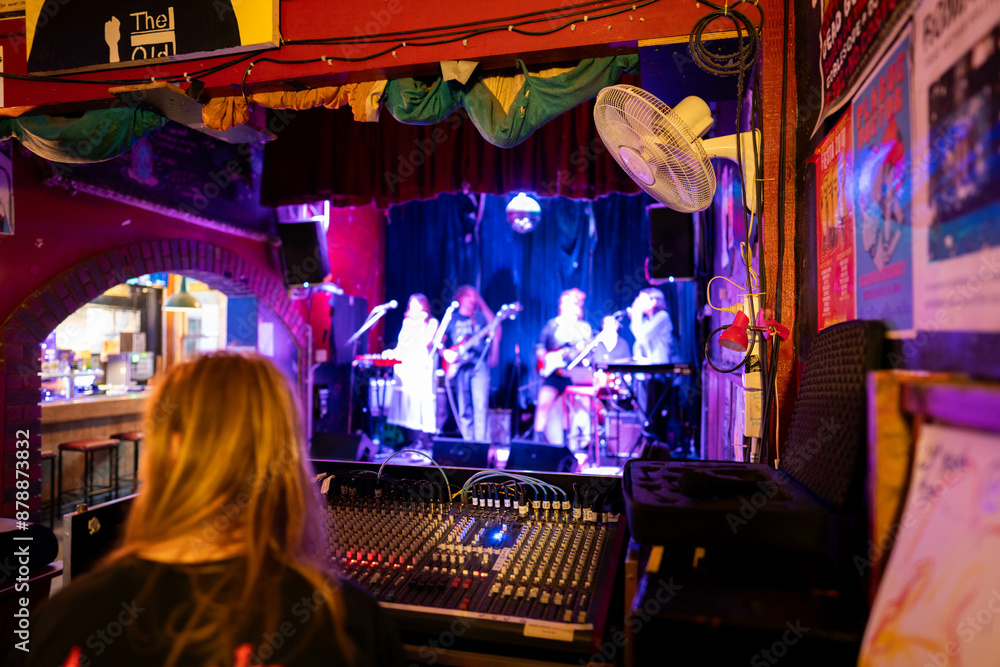 female musician playing guitar band at a rock show to an audience watching. sound check with a switcher in a music venue female musician playing guitar band at a rock show to an audience watching. sound check with a switcher in a music venue