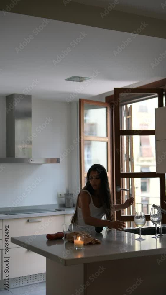 A woman is happily enjoying wine in a trendy kitchen, creating a lively environment A woman is happily enjoying wine in a trendy kitchen, creating a lively environment