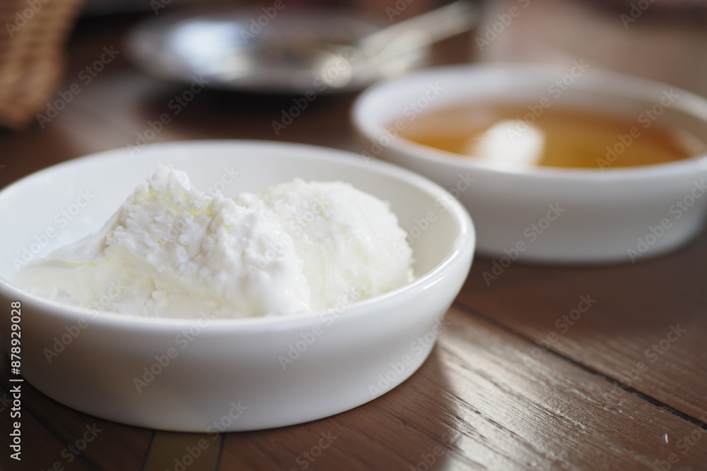 butter cream and honey in a bowl on table . butter cream and honey in a bowl on table .