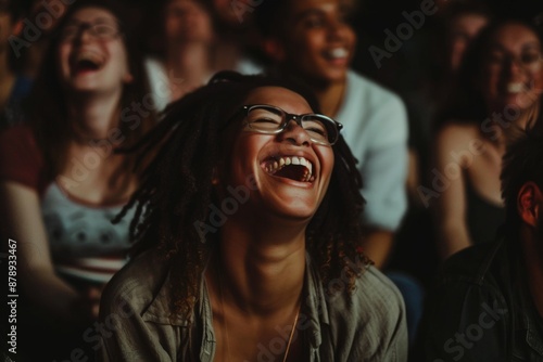 Young woman with friends watching movie in cinema and laughing