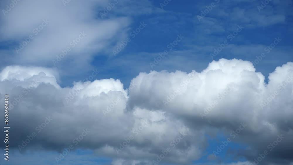 Dramatic time-lapse of Fluffy white clouds drift across a bright blue sky
