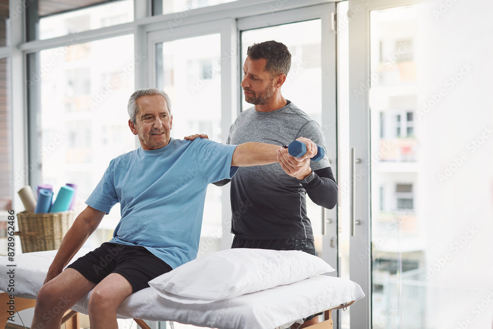 Fototapeta premium Physio, dumbbell and senior man with rehabilitation, arm muscle and check in clinic. Consultation, client and elderly care with physical therapy, wellness and injury support with chiropractor