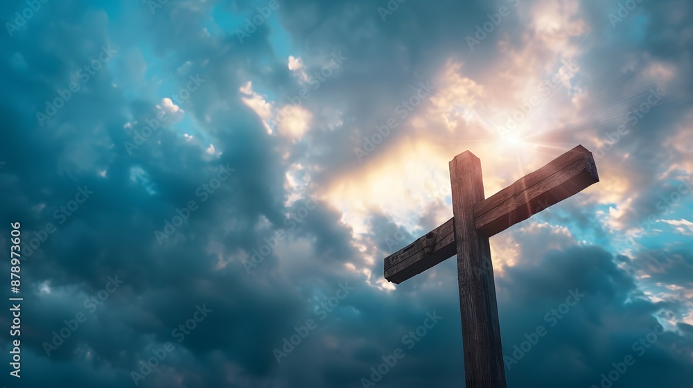 Wooden cross in front of dramatic, cloudy sky with sunlight piercing through. Wooden cross in front of dramatic, cloudy sky with sunlight piercing through.