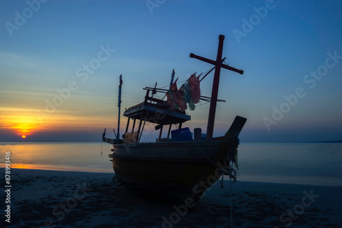 A lone fishing boat on a beautiful calm sea during sunset © tonjung