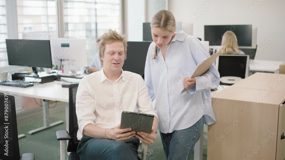 In a modern coworking space, successful young professionals are actively engaged in a collaborative office meeting. They are discussing business strategies and working on tablets and laptops In a modern coworking space, successful young professionals are actively engaged in a collaborative office meeting. They are discussing business strategies and working on tablets and laptops