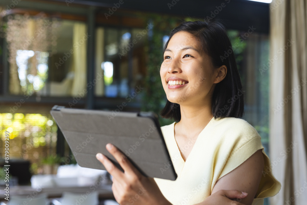 Happy asian woman with short hair using tablet at home Happy asian woman with short hair using tablet at home