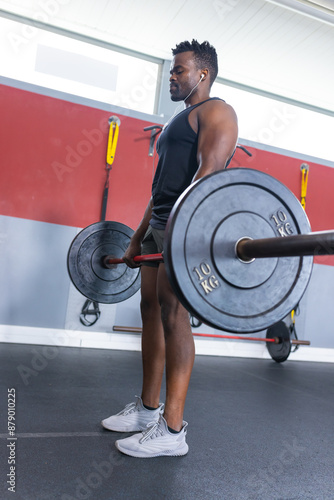 Fit African American man lifting weights at the gym photo