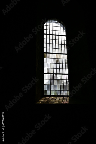 stained glass window in church, light falls through an old church window with mosaic on a wall, background in black, Lund Cathedral, Lunds domkyrka Lund, Skane, southern Sweden, Sweden